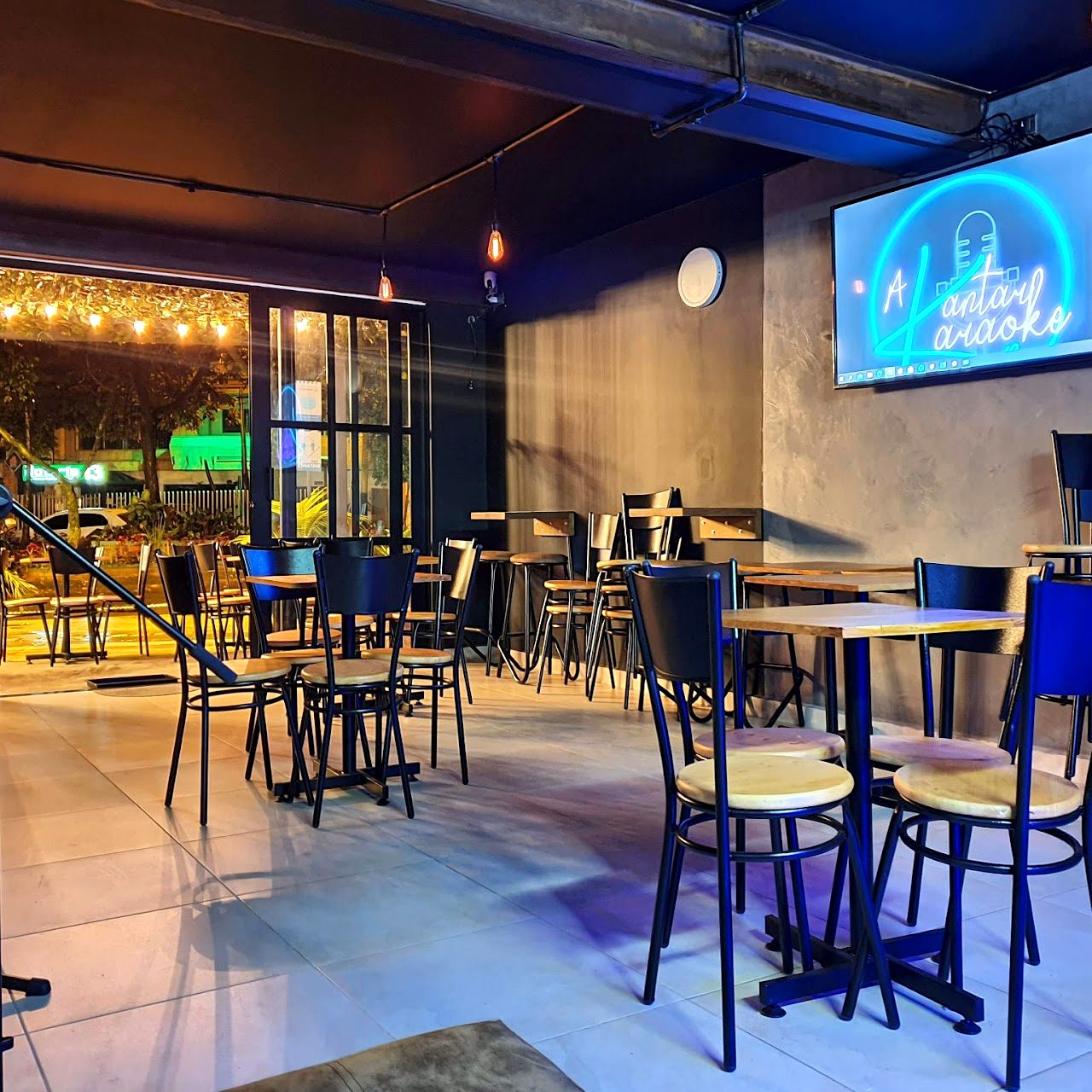 Interior y mesas de A Kantar Karaoke Bar en Laureles